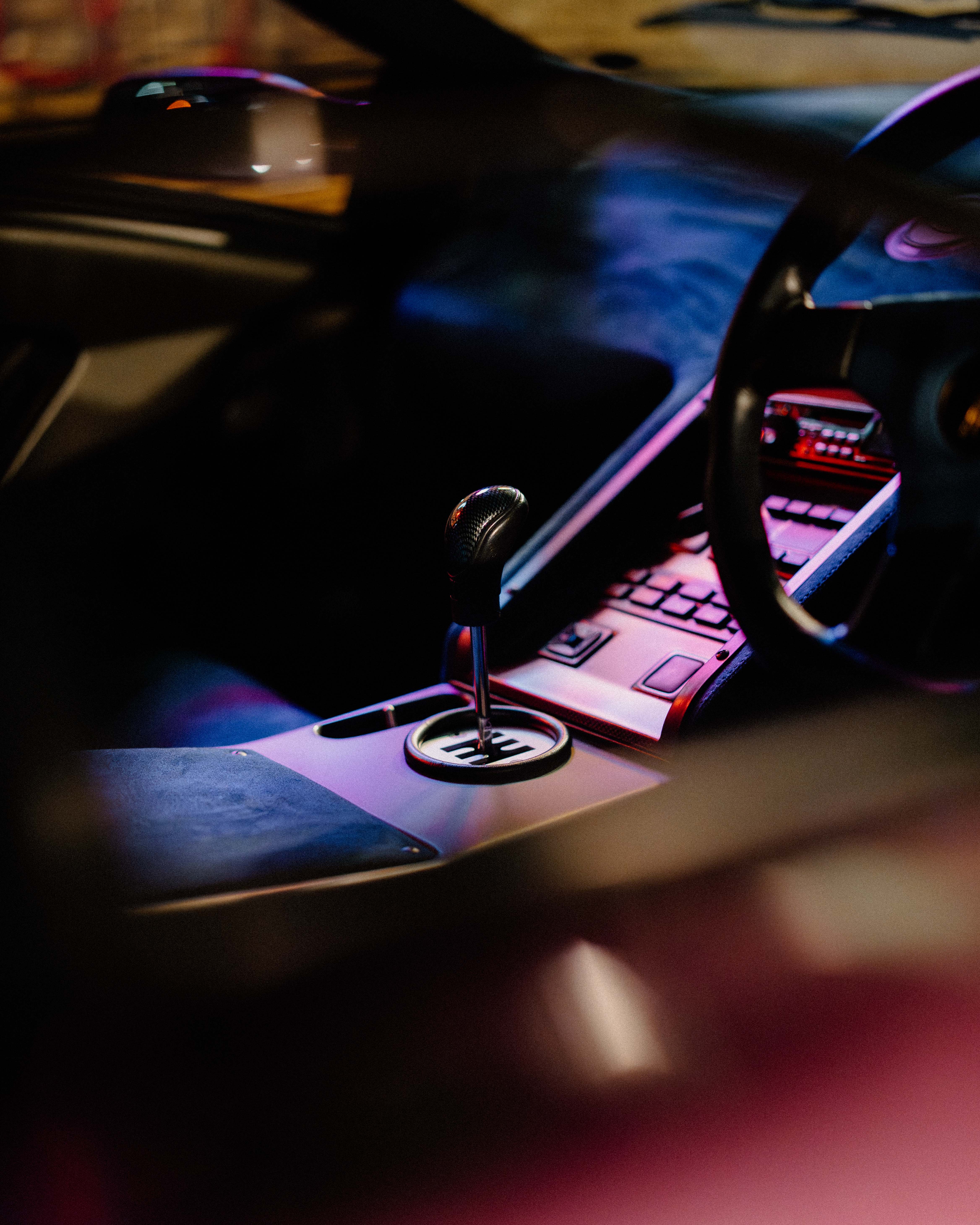 A close up of the interior of a sports car, focusing on the gear stick